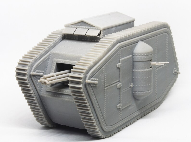 Puede incluir: Un modelo gris de un tanque de la Primera Guerra Mundial con un ca&ntilde;&oacute;n grande y una ametralladora m&aacute;s peque&ntilde;a en la parte trasera. El tanque tiene un dise&ntilde;o distintivo en forma de diamante y est&aacute; hecho de pl&aacute;stico.
