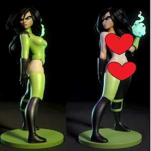 Op de afbeelding: Een groen en zwart beeldje van een vrouwelijk personage met lang zwart haar. De figuur draagt een groen bodysuit met zwarte accenten en laarzen. De figuur staat op een groene cirkelvormige basis. Het personage houdt een gloeiende blauwe bol vast.