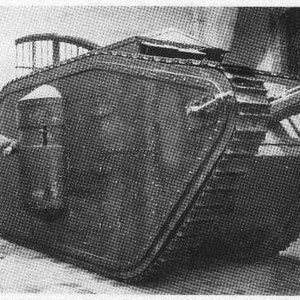 Puede incluir: Una fotograf&iacute;a en blanco y negro de un veh&iacute;culo grande y blindado con un hombre de pie junto a &eacute;l. El veh&iacute;culo tiene una parte delantera grande y redondeada y una serie de orugas en los lados. El hombre lleva un sombrero y un abrigo.