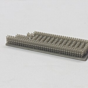 Puede incluir: Primer plano de una maqueta de una fila de sillas impresa en 3D. Las sillas est&aacute;n dispuestas en una cuadr&iacute;cula y est&aacute;n hechas de pl&aacute;stico gris claro.