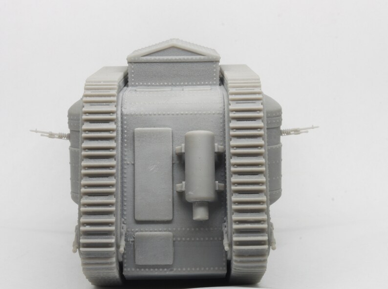 Puede incluir: Un modelo gris de un tanque de la Primera Guerra Mundial con un dise&ntilde;o grande y cuadrado y orugas a ambos lados. El tanque tiene una peque&ntilde;a escotilla rectangular en la parte superior y un gran tubo de escape cil&iacute;ndrico en la parte posterior.