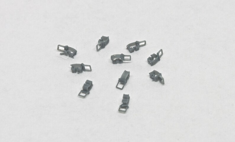 Puede incluir: Diez cierres o sujetadores de metal gris. Los cierres son peque&ntilde;os y tienen un dise&ntilde;o sencillo.