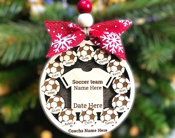 Könnte beinhalten: Ein hölzerner Weihnachtsbaumschmuck in Form eines Fußballs mit einem Fußballtrikot in der Mitte. Der Schmuck ist mit den Namen eines Fußballteams, "Soccer team Name Here", "Date Here" und "Coachs Name Here" verziert.