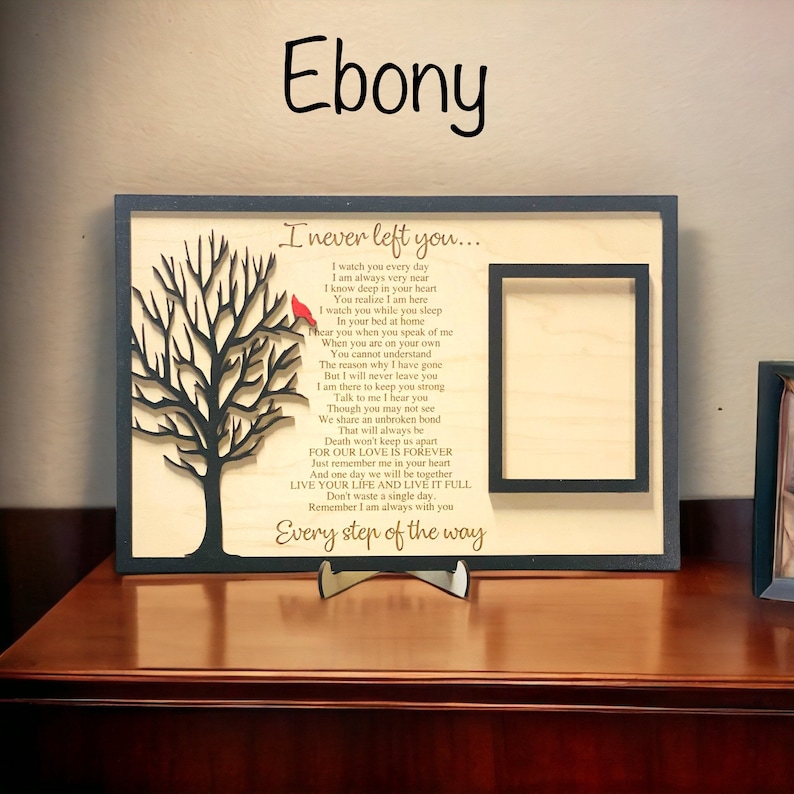May include: A rectangular wooden memorial plaque with a dark frame, featuring a laser-cut black tree with a small red bird, a rectangular photo frame, and the text: I never left you... I watch you every day... Every step of the way.