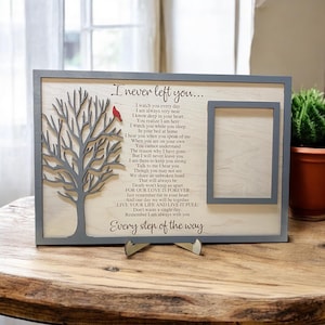 May include: A rectangular wooden memorial plaque with a gray frame, featuring a laser-cut gray tree with a small red cardinal, a photo frame cutout, and the poem I never left you printed in black text on a light wood background.