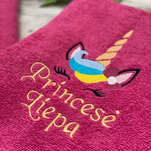May include: Pink towel with a gold embroidered unicorn and the text "Princess Tiepa".