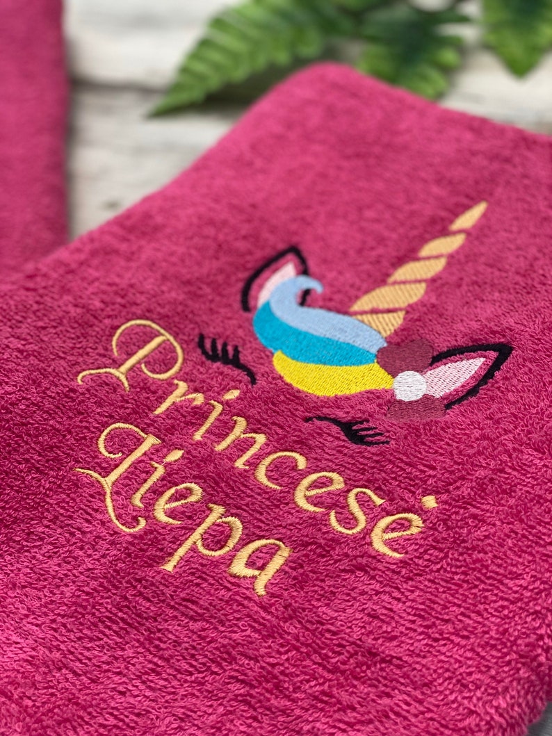 May include: Pink towel with a gold embroidered unicorn and the text "Princess Tiepa".