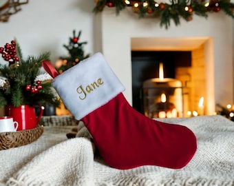 May include: Red velvet Christmas stocking with a white faux fur cuff and the name "Jane" embroidered in gold thread.
