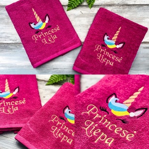 May include: Two pink towels with embroidered unicorns and the text "Princes&eacute; Leja" in gold lettering.