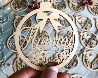 May include: A wooden Christmas bauble with the word "Mummy" inscribed on it. The bauble is decorated with snowflakes and a bow.