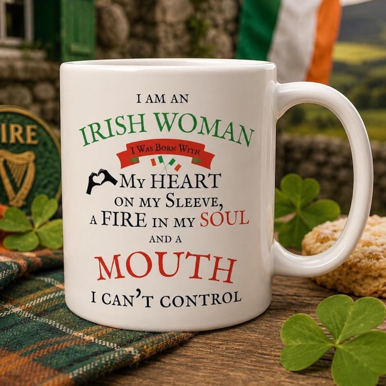 IRISH BFF Gag Gift Ireland Flag Women's Mug Celtic Gaelic Coffee Cup St Patrick Day Gift Eire Tea Mug Present Lucky Cup I am an Irish Woman Includes: A white ceramic mug featuring the text I AM AN IRISH WOMAN I WAS BORN WITH MY HEART ON MY SLEEVE, A FIRE IN MY SOUL AND A MOUTH I CAN'T CONTROL. The design includes a red banner, two small Irish flags, and a black heart-shaped hand icon.