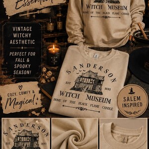 K&ouml;nnte beinhalten: Ein beigefarbenes Sweatshirt mit Rundhalsausschnitt und einem schwarzen Grafikdruck eines Hauses mit dem Text Sanderson Witch Museum Est. 1693 Home of the Black Flame Candle. Das lang&auml;rmelige Kleidungsst&uuml;ck hat einen gerippten Kragen, B&uuml;ndchen und Saum sowie eine Illustration im Vintage-Stil eines Geb&auml;udes mit fliegenden V&ouml;geln dar&uuml;ber.