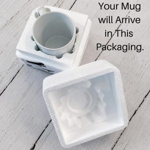 May include: A white ceramic mug nestled inside a two-piece white polystyrene foam protective shipping container. The top piece of the foam packaging is removed and placed beside the base. Text reads: Your Mug will Arrive in This Packaging.
