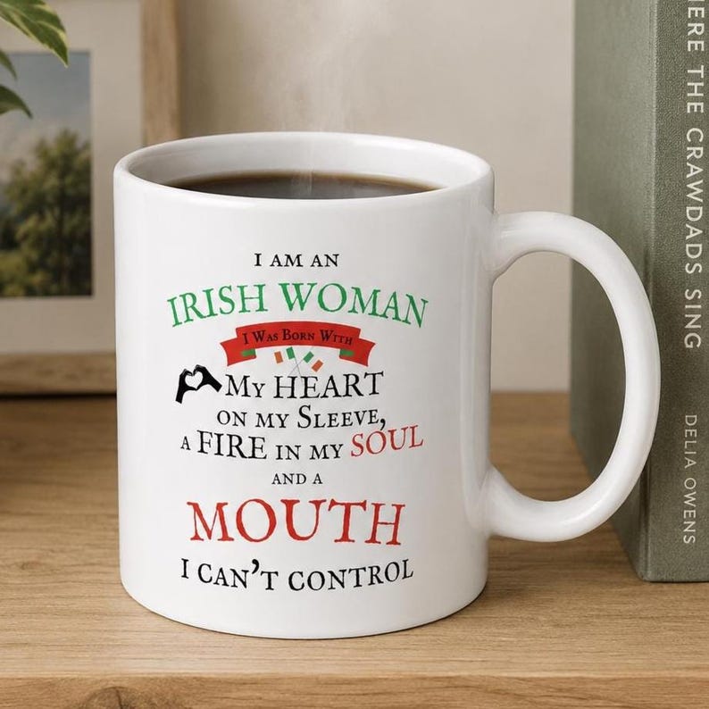 May include: A white ceramic mug featuring black, green, and red text that reads: I AM AN IRISH WOMAN I WAS BORN WITH MY HEART ON MY SLEEVE, A FIRE IN MY SOUL AND A MOUTH I CAN'T CONTROL, accompanied by a small heart-hand icon and two Irish flags.