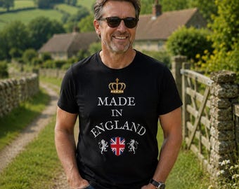 May include: A black short-sleeved t-shirt featuring a gold crown graphic above the white text "MADE IN ENGLAND" and a central Union Jack shield flanked by two white lion illustrations. The shirt has a crew neckline and a standard fit.