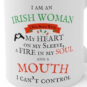 May include: A white ceramic mug featuring green, red, and black text that reads: I AM AN IRISH WOMAN I WAS BORN WITH MY HEART ON MY SLEEVE, A FIRE IN MY SOUL AND A MOUTH I CAN'T CONTROL. The design includes two small crossed Irish flags and a heart hand icon.
