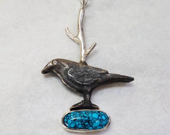 Sterling silver crow with 2mm Zirconia eye and oval turquoise cabochon.  The crow is darkened with Liver of Sulphur.