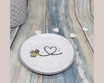 Plato decorativo de arcilla hecho a mano: diseño de abeja, borde plateado.