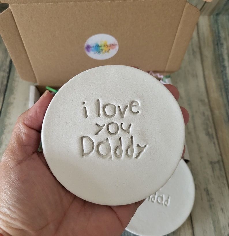 Puede incluir: Posavasos de cer&aacute;mica blanca con las palabras "i love you Daddy" en relieve.