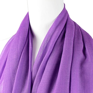 May include: A purple scarf made from a soft, lightweight fabric. The scarf is draped over a mannequin's neck and shoulders.