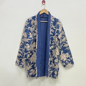 May include: A blue and white quilted jacket with a floral pattern. The jacket has a traditional Japanese style with a wide collar and long sleeves.