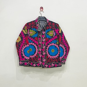 May include: A black embroidered jacket with pink, blue, green, and yellow floral patterns. The jacket has a striped lining and a button closure.
