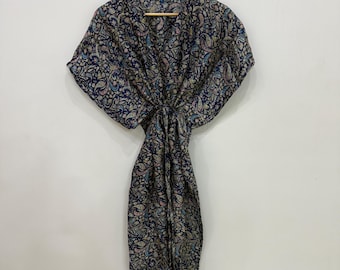 May include: A navy blue paisley print kimono robe hanging on a wooden hanger. The robe has a V-neck and a tie closure at the waist. The paisley pattern includes shades of blue, pink, and beige.