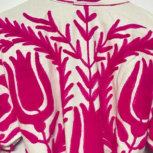 Puede incluir: Batista blanca con dise&ntilde;o floral bordado en rosa. El bordado presenta tulipanes y hojas estilizadas.