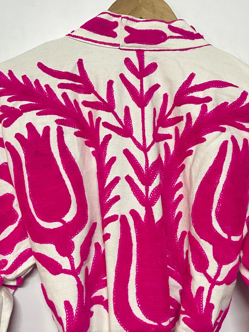 Puede incluir: Batista blanca con dise&ntilde;o floral bordado en rosa. El bordado presenta tulipanes y hojas estilizadas.