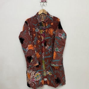 May include: A long-sleeved jacket in a deep reddish-brown hue, featuring intricate kantha stitching and vibrant, multi-colored floral embroidery. The garment displays a variety of orange, black, and teal botanical patterns across the entire surface.