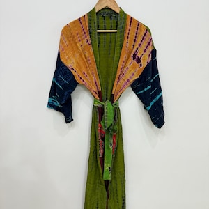 May include: A tie-dye patterned robe with a green, orange, and navy blue color scheme. The robe has long sleeves and a matching tie belt. The robe is hanging on a wooden hanger against a white background.