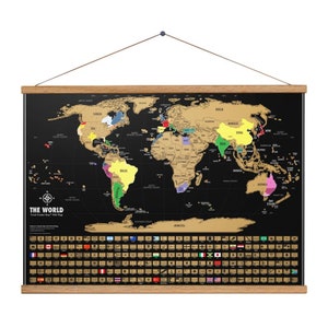 May include: A black scratch-off world map with gold foil accents. The map is framed in wood and includes a set of flags from around the world. The text "THE WORLD" is printed at the bottom of the map.
