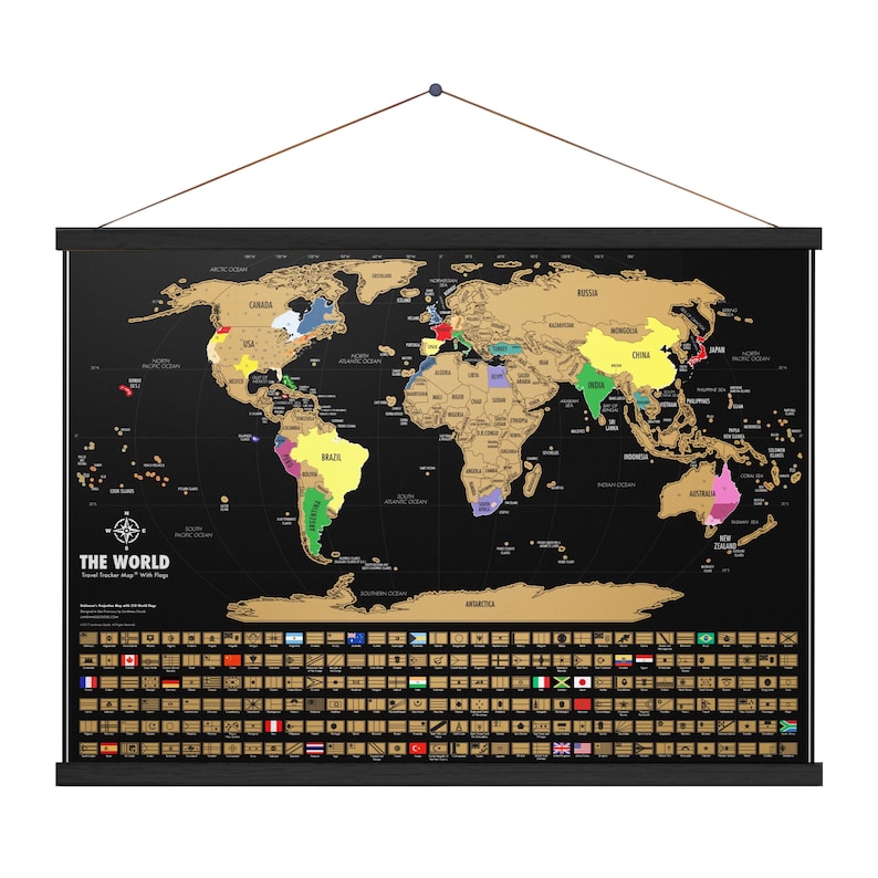 May include: A black world map with gold foil continents and colorful country outlines. The map includes a scratch-off surface, a compass rose, and the text "THE WORLD". A row of country flags is at the bottom.