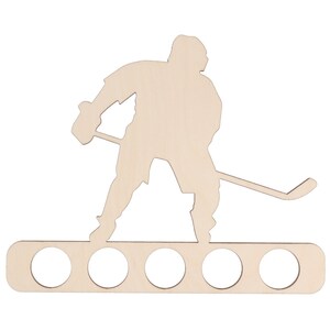 May include: Wooden hockey player silhouette with a stick and a base with six holes for holding beverage cans.