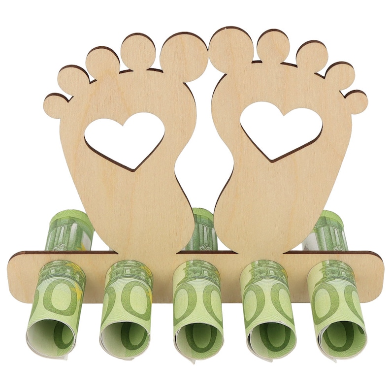 May include: A wooden money holder shaped like two feet with heart cutouts. The holder has slots for rolled-up currency, with several rolls of green and white bills visible. The design is light brown.
