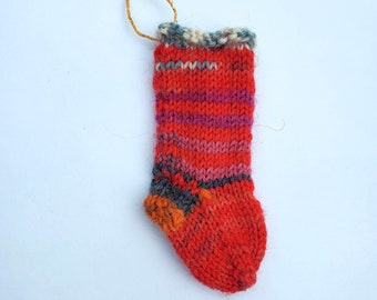 Whimsical hand knitted miniature Christmas stocking ornament.