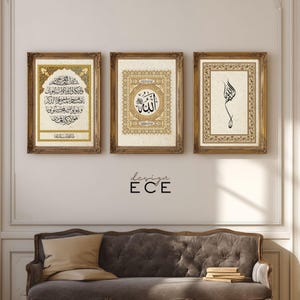Op de afbeelding: Drie ingelijste islamitische kunstprints met sierlijke gouden frames. De prints tonen Arabische kalligrafie in zwart en goud op een crèmekleurige achtergrond. De frames worden boven een grijze bank weergegeven. De tekst "design ECE" staat eronder.