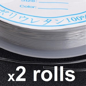May include: Two rolls of clear elastic string, labelled "x2 rolls". The string is wound around a white spool with blue lettering that reads "Size: Color: バリウレタン100%".
