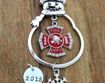 Può includere: Ciondolo a forma di pupazzo di neve argentato con un ciondolo rosso e bianco dei vigili del fuoco, un ciondolo a forma di fiocco di neve e un ciondolo 2018.  Scegli un ciondolo.