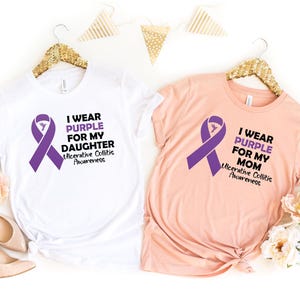 May include: Two t-shirts with a purple ribbon and the text "I wear purple for my daughter/mom" and "Ulcerative Colitis Awareness".
