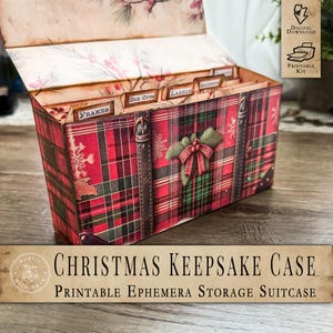 May include: A Christmas Keepsake Case with a red and green plaid pattern. The case has a decorative bow and a sprig of greenery on the front. The case is open, revealing labeled dividers. The text on the case reads "Christmas Keepsake Case" and "Printable Ephemera Storage Suitcase."