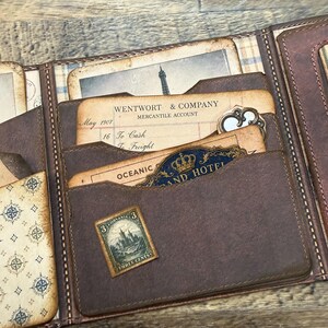 Printable vintage travel wallet kit with antique map designs, ephemera, and crafting elements for journaling and scrapbooking