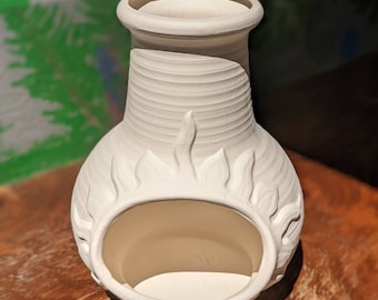 Puede incluir: Un jarrón de cerámica blanco con una abertura ancha y una base bulbosa. El jarrón presenta un diseño texturizado y acanalado en el cuello y cortes decorativos en forma de llama alrededor de la abertura. El jarrón no está esmaltado.