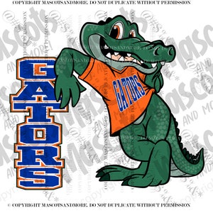 Puede incluir: Una mascota de dibujos animados de un cocodrilo verde que lleva una camisa naranja con la palabra "GATORS" impresa en ella. La mascota se apoya en un cartel azul y naranja con la palabra "GATORS" impresa en él.