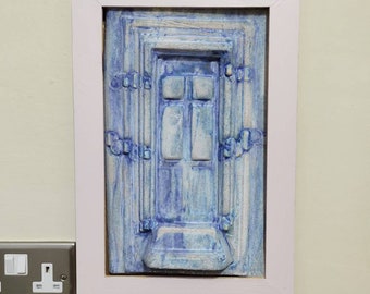 ceramic sculpture wall hanging based on shape and character of a weathered door and surround