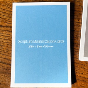 May include: A blue card with white text that reads "Scripture Memorization Cards Bible + Book of Mormon".
