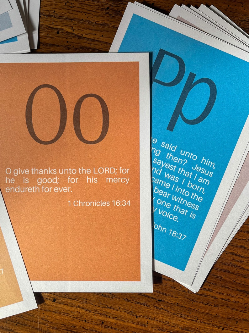 May include: Two orange cards with the letter "O" printed in black on each card. The cards are stacked on top of each other. The top card has the text "O give thanks unto the LORD; for he is good; for his mercy endureth for ever. 1 Chronicles 16:34" printed in black on the bottom half of the card.