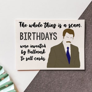 May include: A humorous birthday card featuring a cartoon illustration of Ron Swanson from the TV show Parks and Recreation. The card reads "The whole thing is a scam. Birthdays were invented by Hallmark to sell cards."
