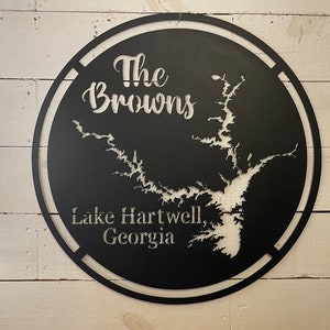 May include: Black metal round sign with the text "The Browns" and "Lake Hartwell, Georgia" in a white font.