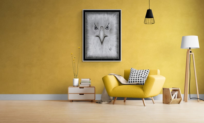 K&ouml;nnte beinhalten: Ein gelber Sessel mit einem schwarz-wei&szlig; karierten Kissen steht in einem Wohnzimmer mit einer gelben Wand. Ein schwarz gerahmtes Bild eines Adlergesichts h&auml;ngt an der Wand &uuml;ber einem wei&szlig;en Beistelltisch mit B&uuml;chern und einer Vase mit getrockneten Blumen. Eine Stehlampe mit einem wei&szlig;en Schirm steht in der Ecke.